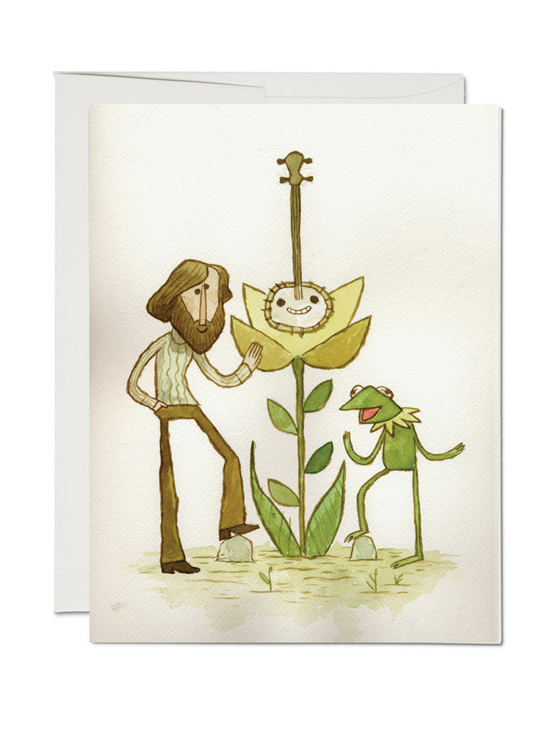An illustration for The Banjo greeting card from Spoke Art—a bearded man and a cheerful frog stand by a smiling banjo-faced flower. The charming scene creates an inviting art greeting card.
