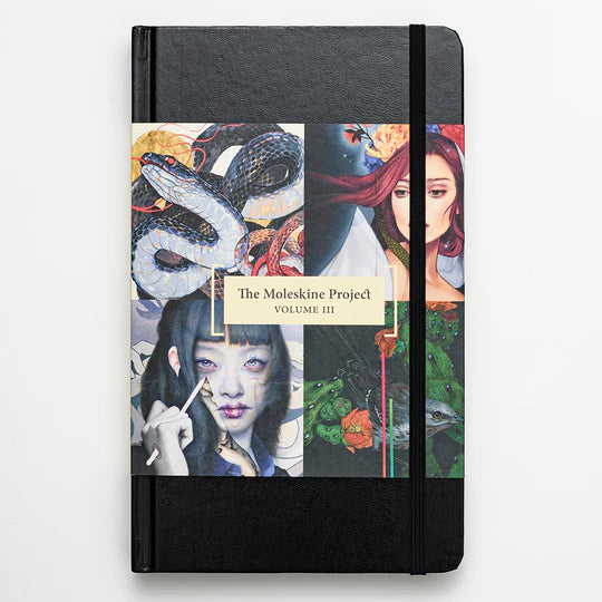 A black Paragon Books notebook showcases a collage of vibrant art from Spoke Arts international artists, titled The Moleskine Project, Volume III, featuring a snake, a woman in a red shawl, and an individual with long dark hair holding a brush.