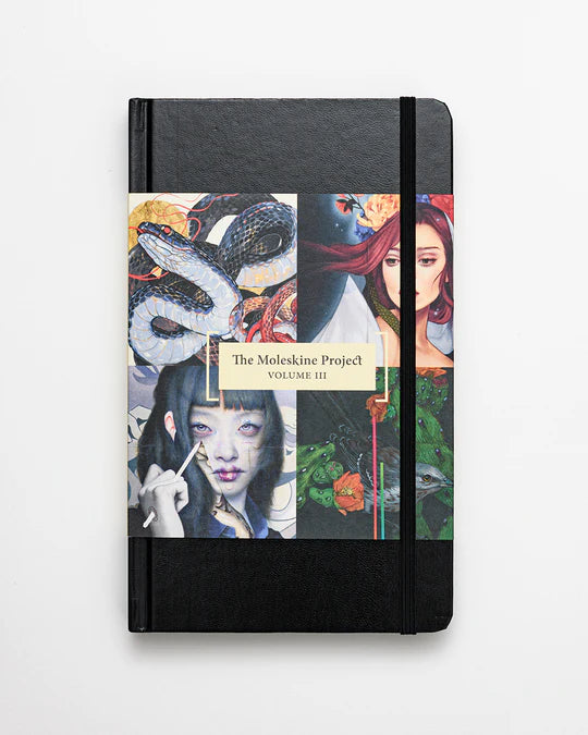 A black Paragon Books notebook showcases a collage of vibrant art from Spoke Arts international artists, titled The Moleskine Project, Volume III, featuring a snake, a woman in a red shawl, and an individual with long dark hair holding a brush.