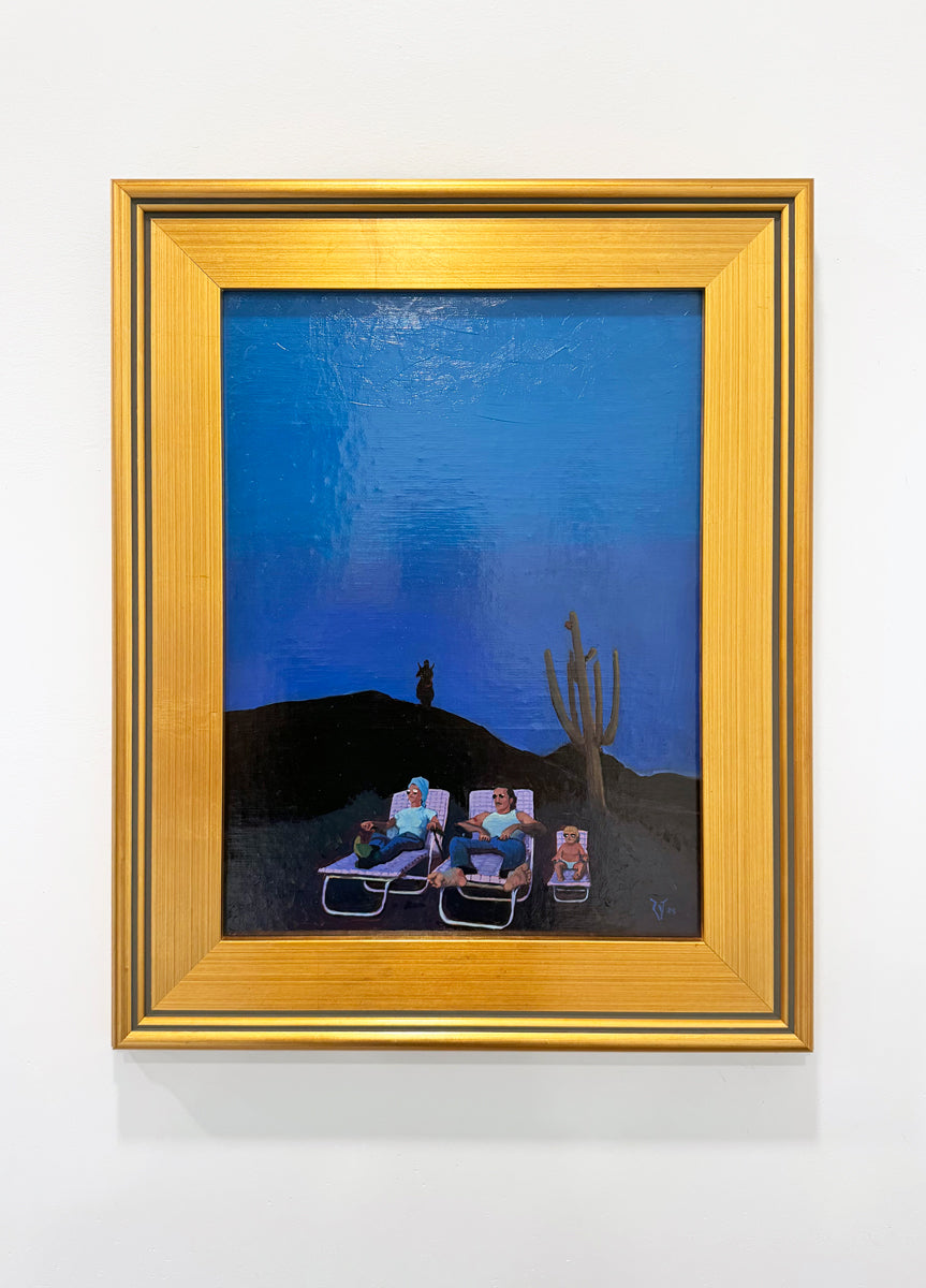 A framed Spoke Art painting features four people lounging by a cactus under a dark blue evening sky, with a silhouetted figure on a distant hill. The artwork comes in a gold frame accented with black.