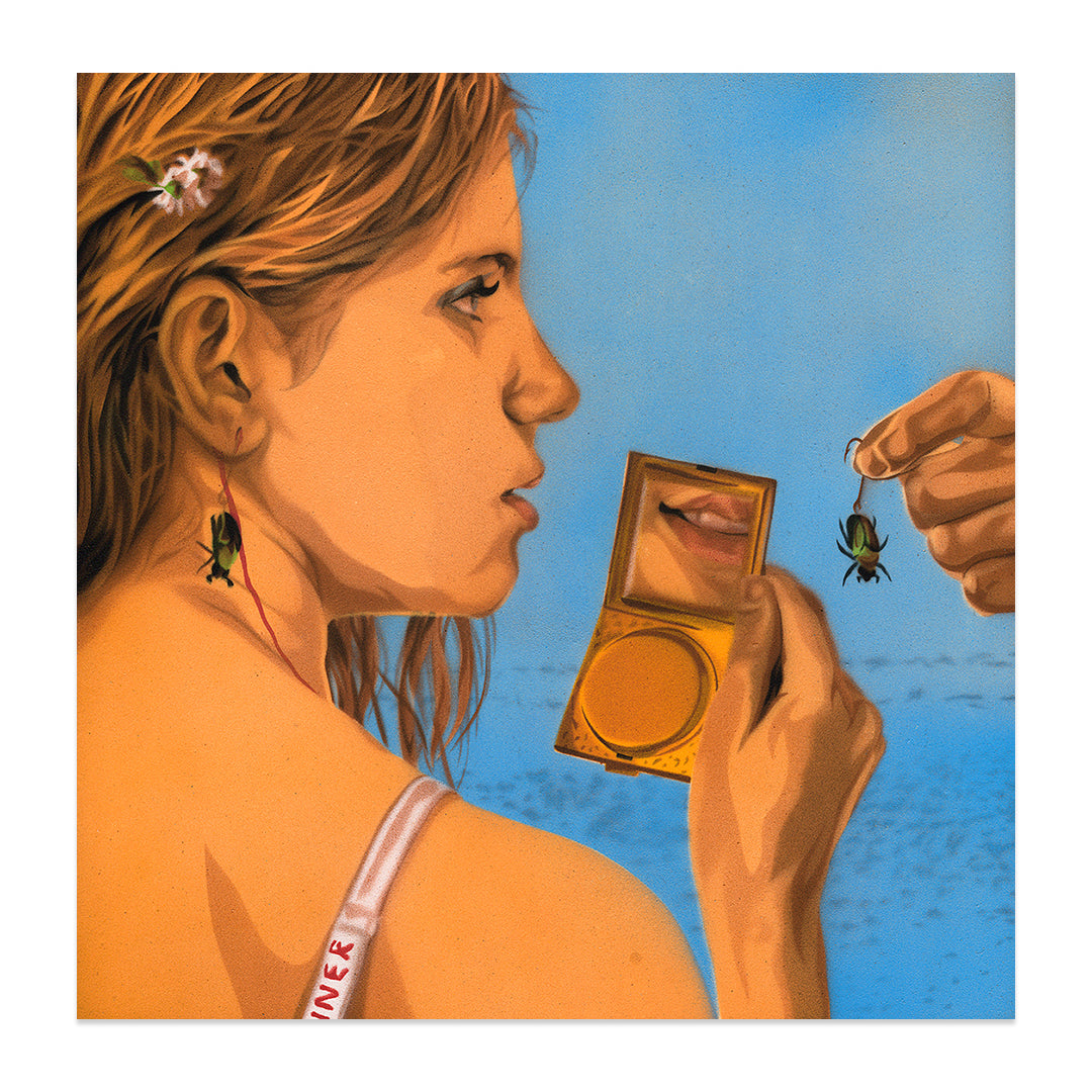A woman with wet hair sits on a beach, holding a compact mirror reflecting her smile. A beetle is near her ear as another is offered by hand. Captured under the clear blue sky and sea, this scene is part of Nick Comparones limited edition pigment print collection, reminiscent of a Wes Anderson Tribute.