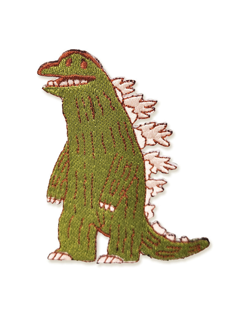 An embroidered Spoke Art patch inspired by Scott C., showing a green cartoon Thunder Lizard with white back and tail spikes, and bold red accents on its face and outline.