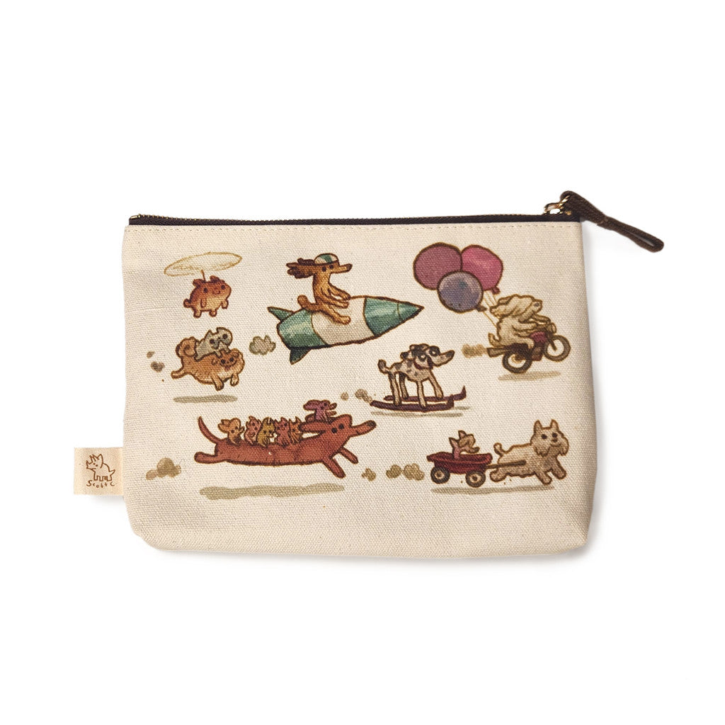 A beige Spoke Art pouch showcases playful Dogs On The Go illustrations of dogs riding a rocket, sled, motorcycle with balloons, red wagon, and a red dog-shaped vehicle—celebrating fun adventures together.