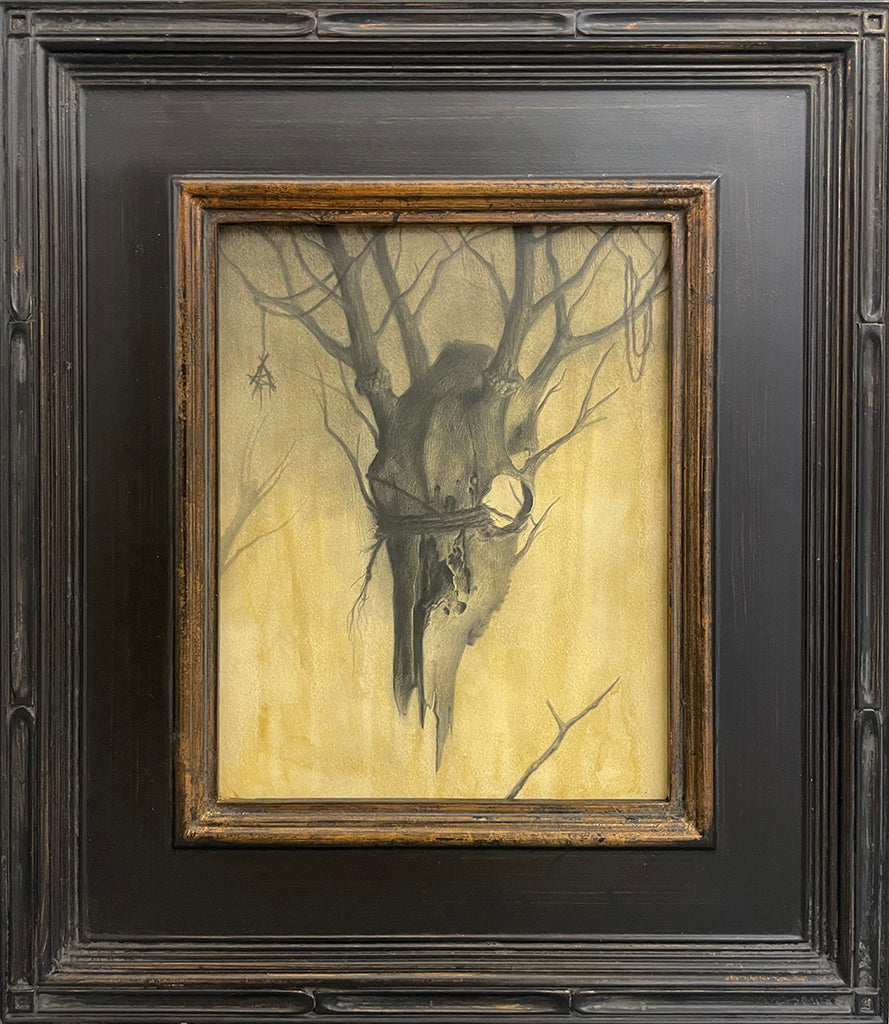 A framed painting by Zachary Oldenkamp shows a weathered animal skull hanging from bare branches on a muted yellow backdrop, creating an eerie mood. This piece is featured in the Spoke Art 15th Anniversary Show by Spoke Art.
