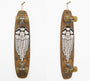 A GATS-designed longboard hangs vertically against the wall, featuring a wooden deck with an acrylic illustration of a bearded face. Retro-style wheels and metal trucks complete this Artisan Market San Francisco-inspired vintage piece.