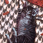 A gray tabby cat, with extra eyes and paws, playfully lounges on a patterned floor surrounded by autumn leaves. Painted in Casey Weldons surreal style with acrylic on wood panel, it captures Adelines dreamlike charm.