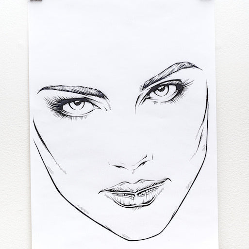 Rhys Coopers preliminary sketch features a womans face with detailed eyes and lips, clipped to a white wall. The bold lines of ink on paper emphasize her facial features, creating an expressive and minimalist look.