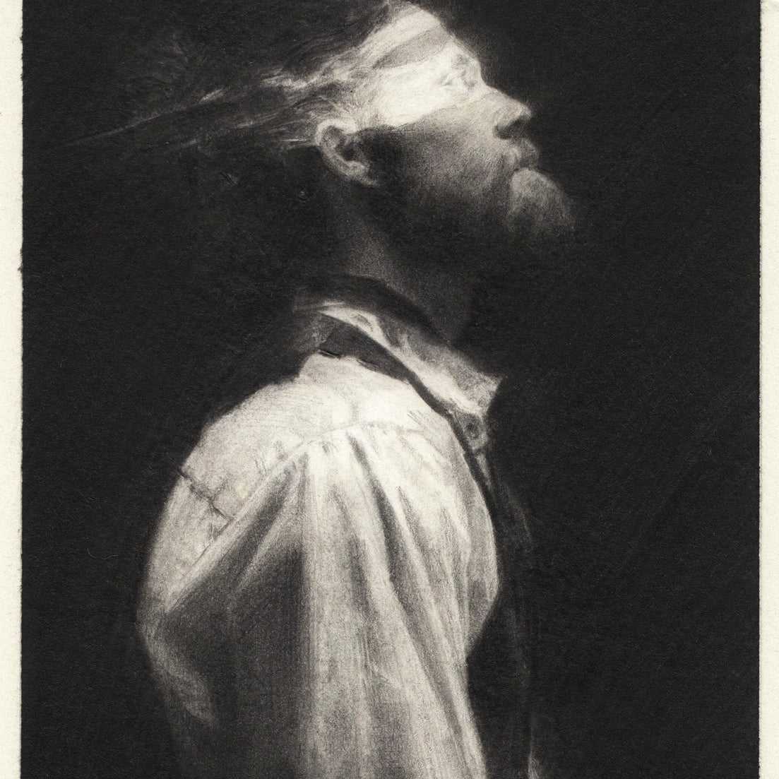 The portrait, styled in black-and-white like Karla Ortizs work, features a bearded person with a bun. Wearing a white shirt and suspenders, they gaze upward as light illuminates their face against the dark background, reminiscent of an evocative graphite on paper exhibition piece by Karla Ortiz.