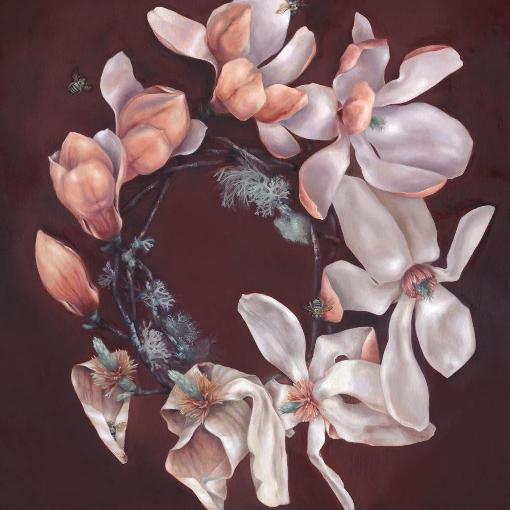 A circle of magnolia flowers, reflecting Jen Lobos style, forms against a dark backdrop. The blooms are white and pale pink with soft petals. Small green leaves and subtle textures enhance this enchanting arrangement.