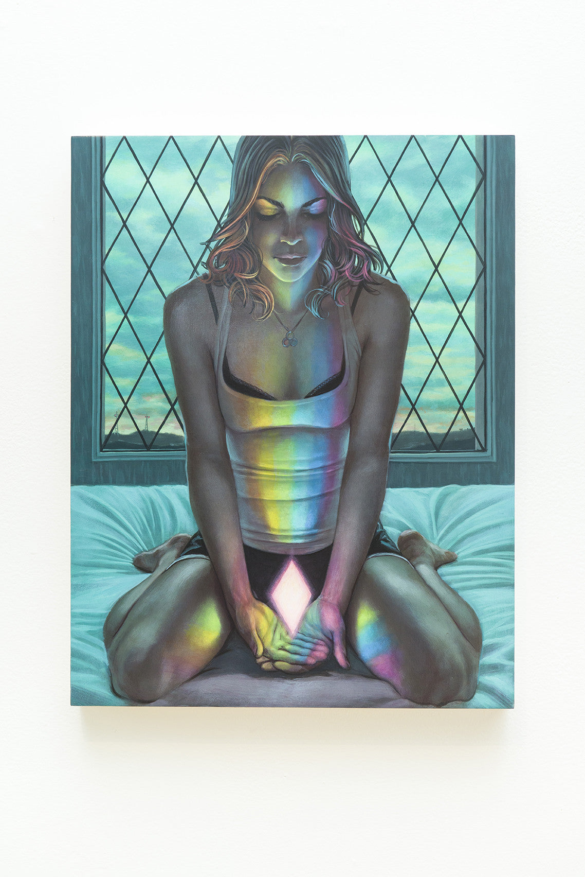 Casey Weldons acrylic on wood painting shows a person sitting cross-legged on a bed with a glowing geometric shape. Their face and body glows in vibrant rainbow hues, suggesting refraction, against the backdrop of a window with a diamond grid pattern.