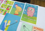A table showcases vibrant posters and books. One digital print features a pink creature with Gonnadie text, while another highlights Joan Cornellàs iconic style with a person in a yellow suit with their face on their backside. Nearby are illustrated covers, including one titled Zonzo.