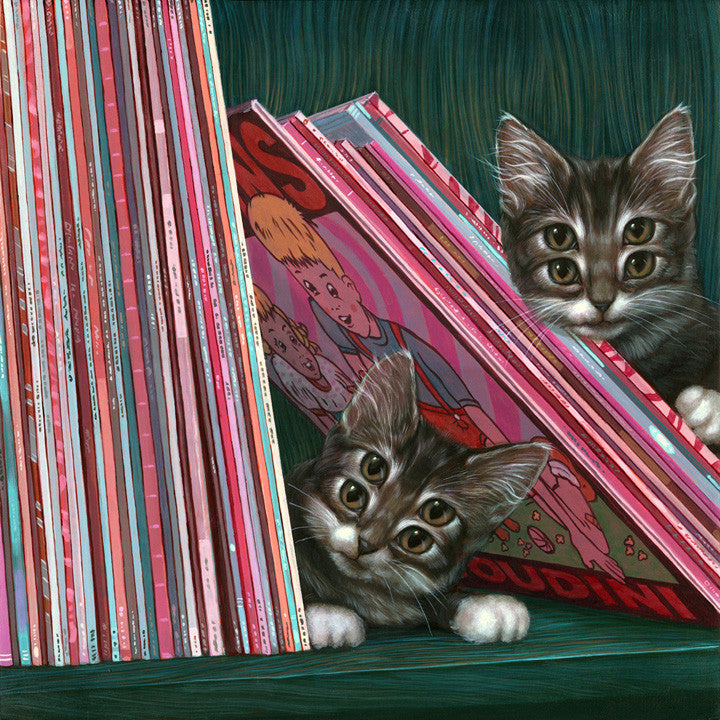 Two curious kittens, Louie & Nico, peek from behind comic book stacks on a shelf. Their wide eyes and playful expressions enhance the vibrant scene of colorful comic spines—a delightful nod to Casey Weldons whimsical style.
