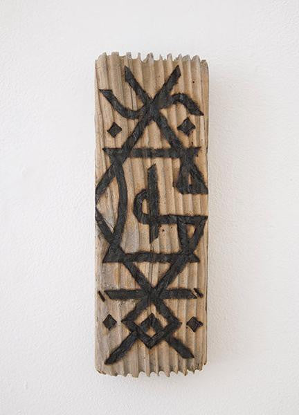 A GATS rectangular wood art piece, showcasing a carved abstract geometric pattern with intersecting lines in dark ink. Its textured surface mimics burnt driftwood and is displayed on a white wall.