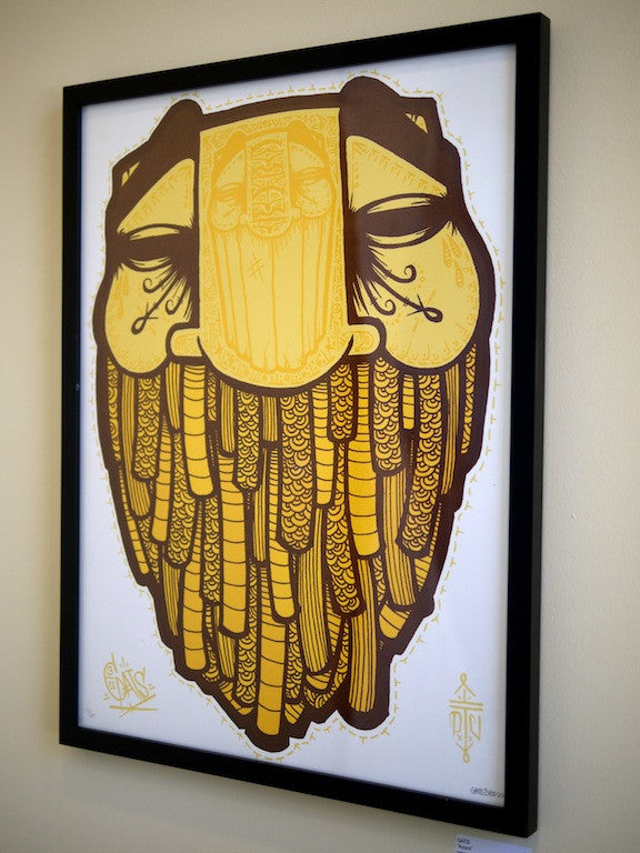 This GATS-framed artwork showcases a stylized face with closed eyes, using yellow and brown hues. It features geometric patterns, intricate line work, and a textured beard that evokes an acorn print and a serene expression.
