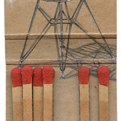 A graphite sketch of an Eames Chair on a cardboard matchbook cover, complete with six red-tipped matches, is presented by Jason DAquino. This artwork cleverly blends iconic design with everyday items for a captivating effect.