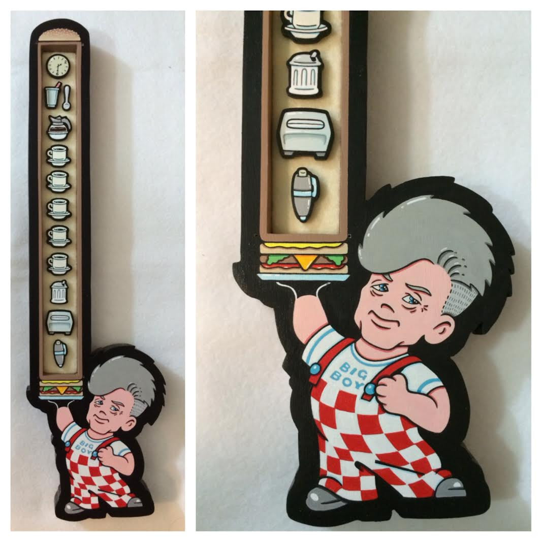 A cartoon character in checkered overalls with a pompadour holds a large burger, reflecting Matt Ritchies playful style. Alongside is a mixed media display of kitchen items like a toaster and rolling pin.