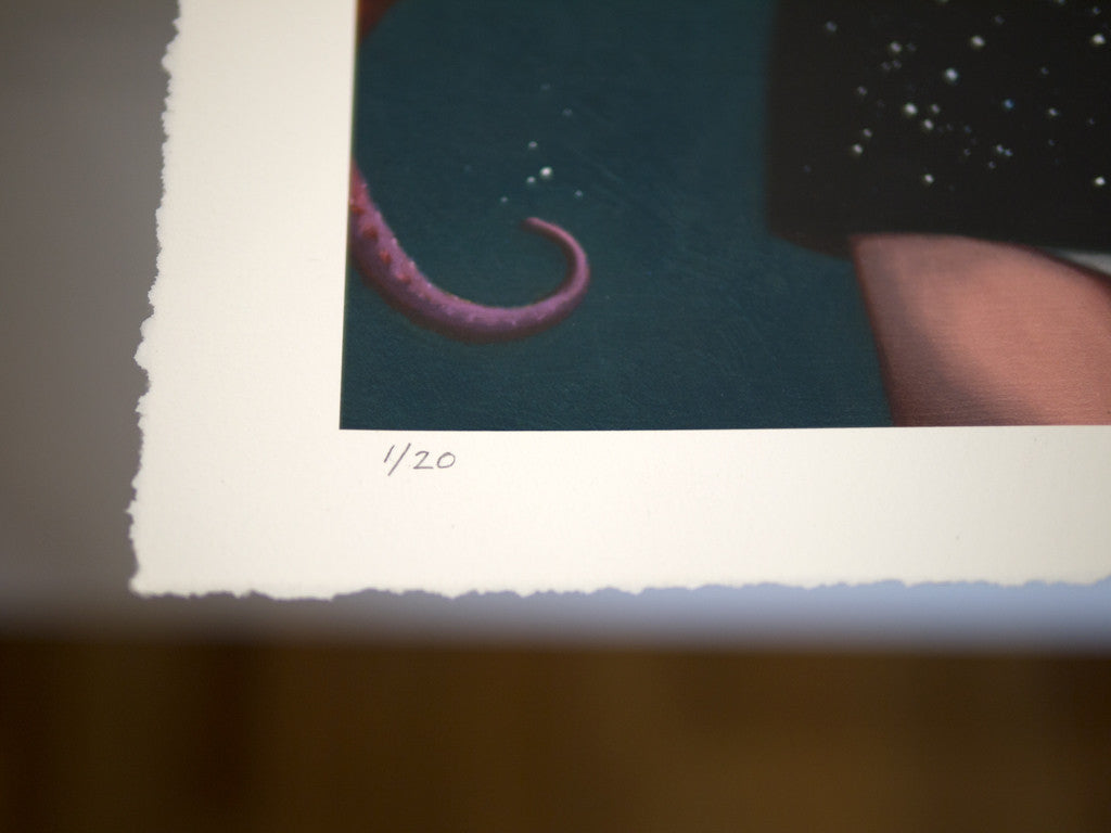 Close-up of a limited edition fine art giclee print by Ana Bagayan, featuring a textured edge and handwritten 1/20. The artwork showcases a pink tentacle against a dark background.