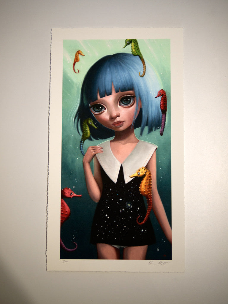 Ana Bagayans limited edition illustration showcases a blue-haired girl in a black dress with a white collar, surrounded by vibrant seahorses. Set against a green, watery backdrop, this whimsical undersea scene is beautifully rendered in a fine art giclee print.