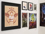 A gallery wall highlights framed artworks, including David Moscatis striking archival pigment print of a person with wings, small portraits, and vibrant abstracts. These pieces from the Lord of the Thrones exhibition are precisely arranged on a pristine white wall.