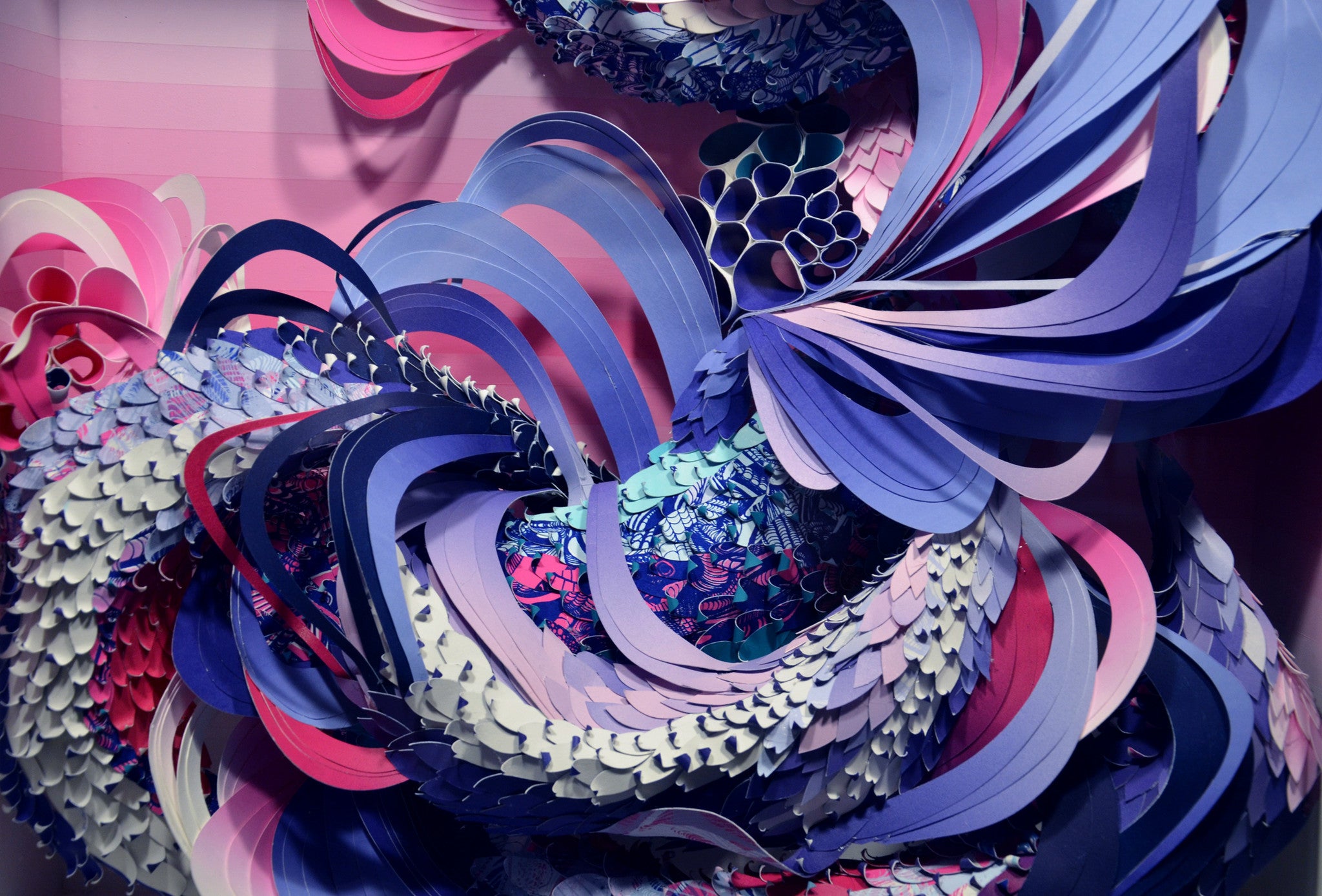 Abstract art by Crystal Wagner uses layered paper in blue, pink, and purple, with swirling patterns similar to Heliotropic I. Intricate cutouts create a 3D flow reminiscent of Art Basel Miami Beach exhibitions.
