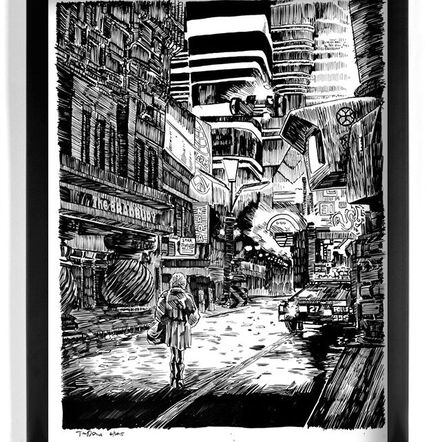 Tim Doyle’s framed pen and ink illustration depicts a futuristic cityscape akin to Blade Runner, with a lone figure walking on a rain-soaked street, surrounded by towering, intricate buildings adorned with signs and a retro police car in the background.