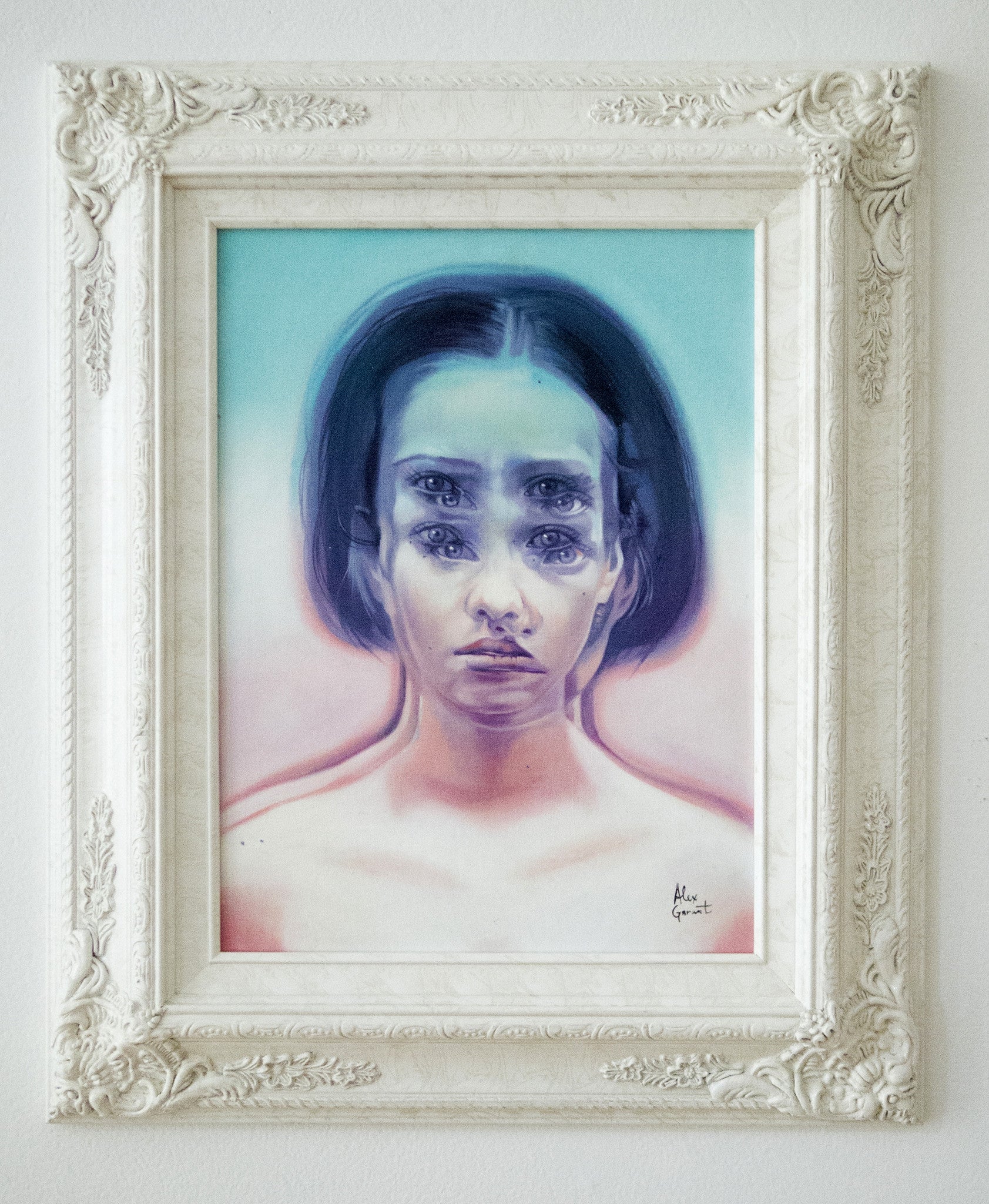 The artwork Nostalgia’s Got The Blues by Alex Garant depicts a surreal woman with multiple eyes and mouths, using soft blues and pinks in oil on canvas, elegantly framed in ornate white.