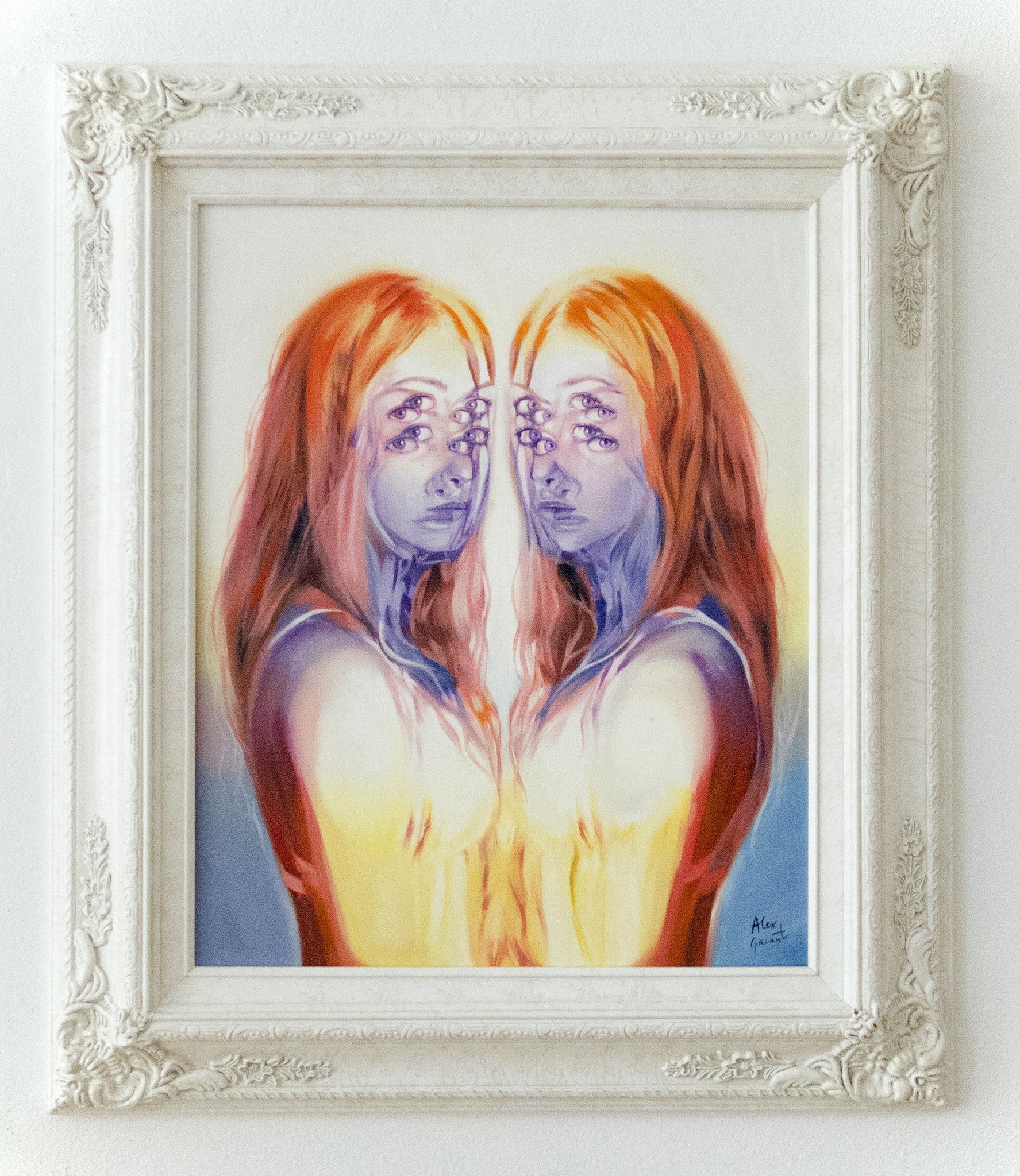 A framed oil on canvas by Alex Garant showcases two identical, multi-eyed figures with long hair in vibrant colors, creating a mirrored surreal effect, all presented in an ornate white frame at the Spoke Art Gallery.