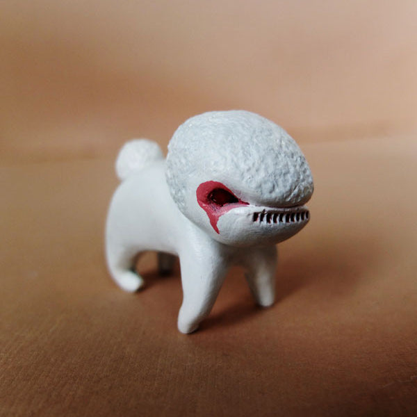 A hand-sculpted resin creature by Doubleparlour features a poodle-like body with a fish-shaped head, textured surface, open red mouth, and sharp teeth. Set against a tan background, it captivates art enthusiasts.