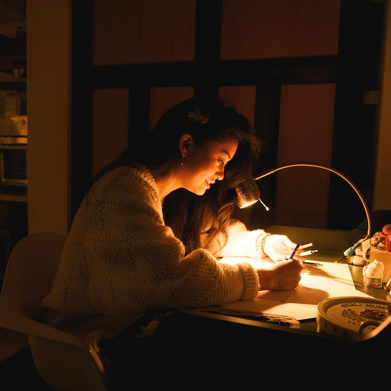 photo of JP Neang working on a drawing in her studio