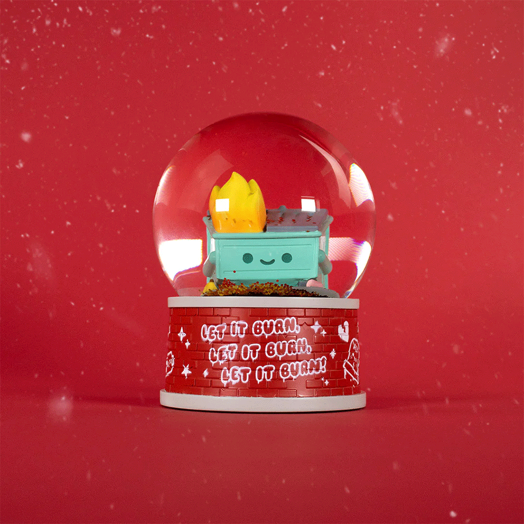 The 100% Soft Dumpster Fire Snow Globe features a smiling dumpster with a playful flame inside on a red background. The base reads “LET IT BURN,” and swirling white flecks mimic falling snow for a festive touch.