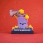 The 100% Soft Lil Meltdown collectible is a cute purple cartoon volcano toy with a happy face, erupting yellow lava and gray smoke. It stands on a dark base labeled "HAVIN A MELTDOWN" against a solid red background.
