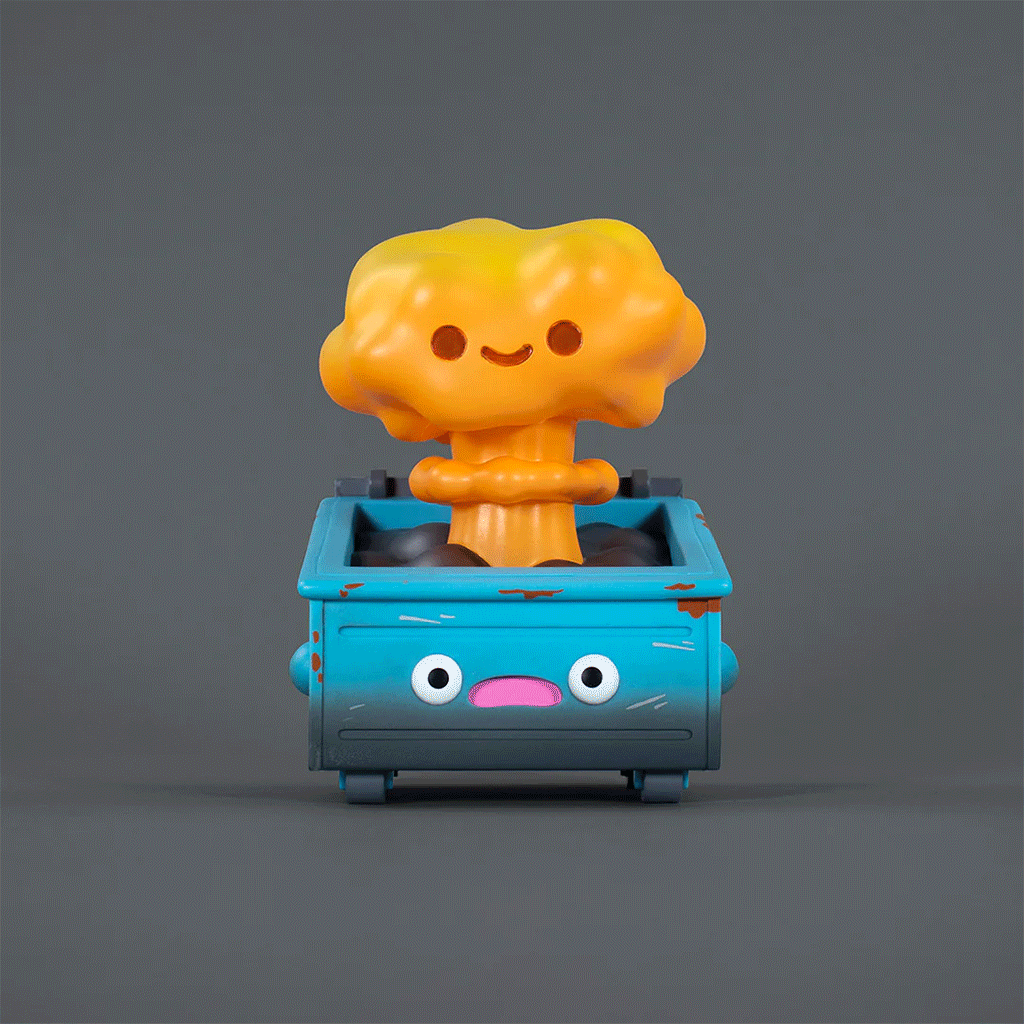 A charming vinyl figure by 100% Soft, the Nuclear Dumpster Fire features a smiling orange mushroom cloud emerging from a distressed blue dumpster with a cartoon face, all set against a plain gray background.