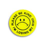 A yellow circular hard enamel pin by Spoke Art features a black sad face and “PLEASE BE KIND I’M LOSING MY MIND” around the edge—a limited edition badge, perfect for fans of Special Ed Toys.