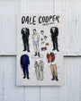 Dale Cooper paper doll set with various outfits on a wooden background
