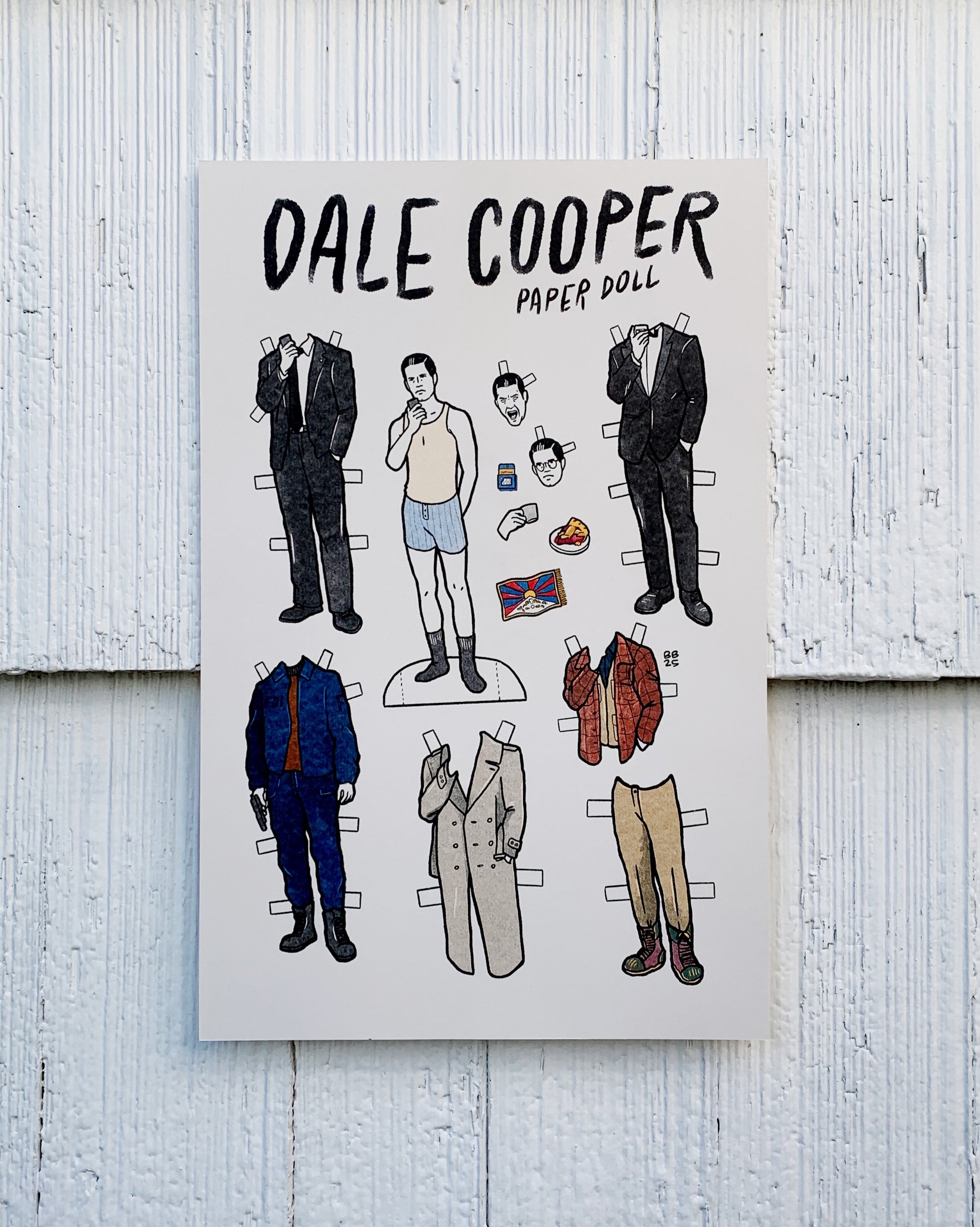 Dale Cooper paper doll set with various outfits on a wooden background