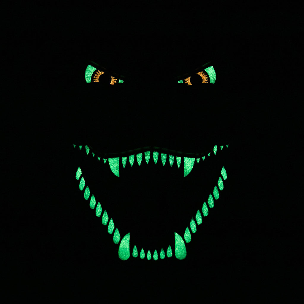 A photo of the sculpture in the dark with the eyes and teeth of Godzilla glowing in the dark