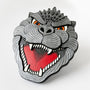 Mixed media sculpture of an enamel pin of Godzilla's head