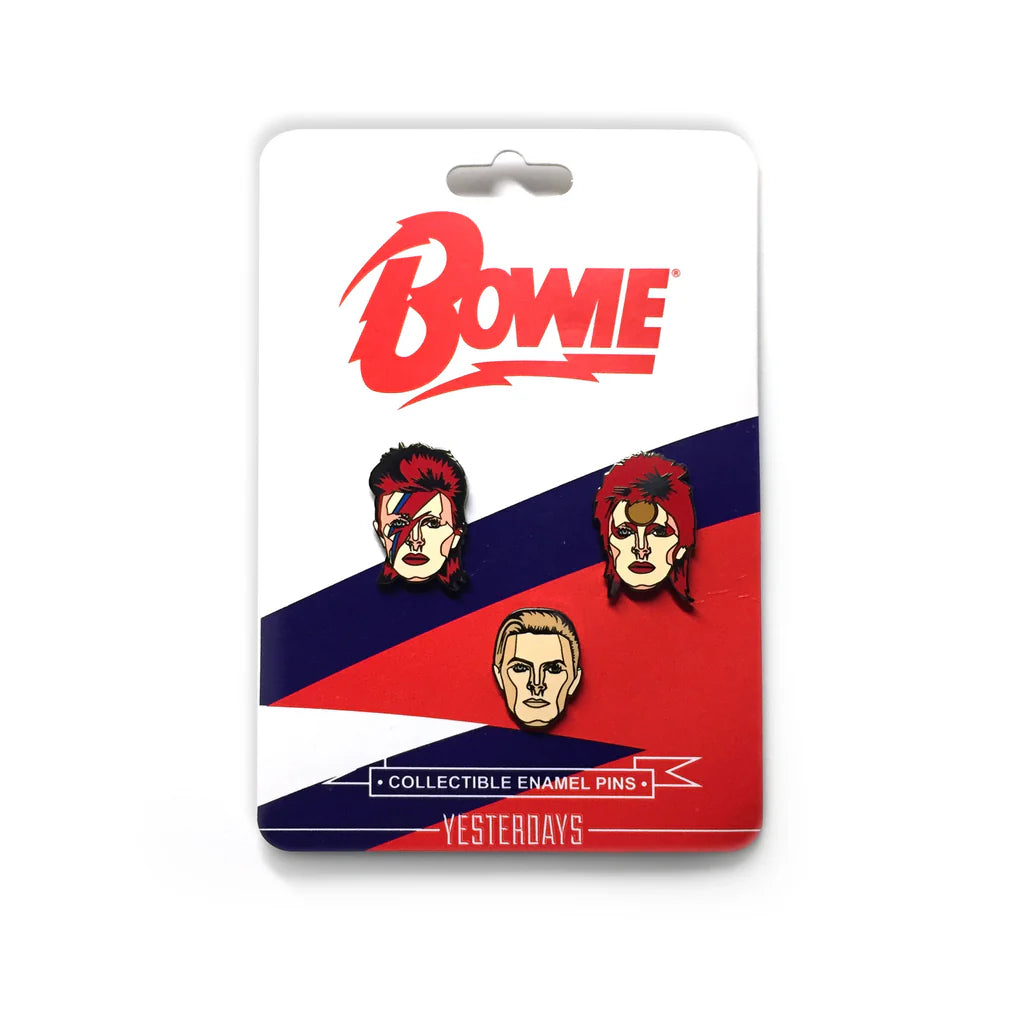 A set of three limited edition hard enamel pins by Spoke Art, each featuring stylized illustrated faces of David Bowie in iconic looks, mounted on a card with Bowie in bold red letters and a red, white, and blue design.