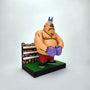 A Geoff Trapp clay figurine of a muscular boxer with a blue crown, purple gloves, red shorts, and black shoes stands on a green platform with a cartoon crowd—ideal for any Mike Tyson's Punchout art collection.