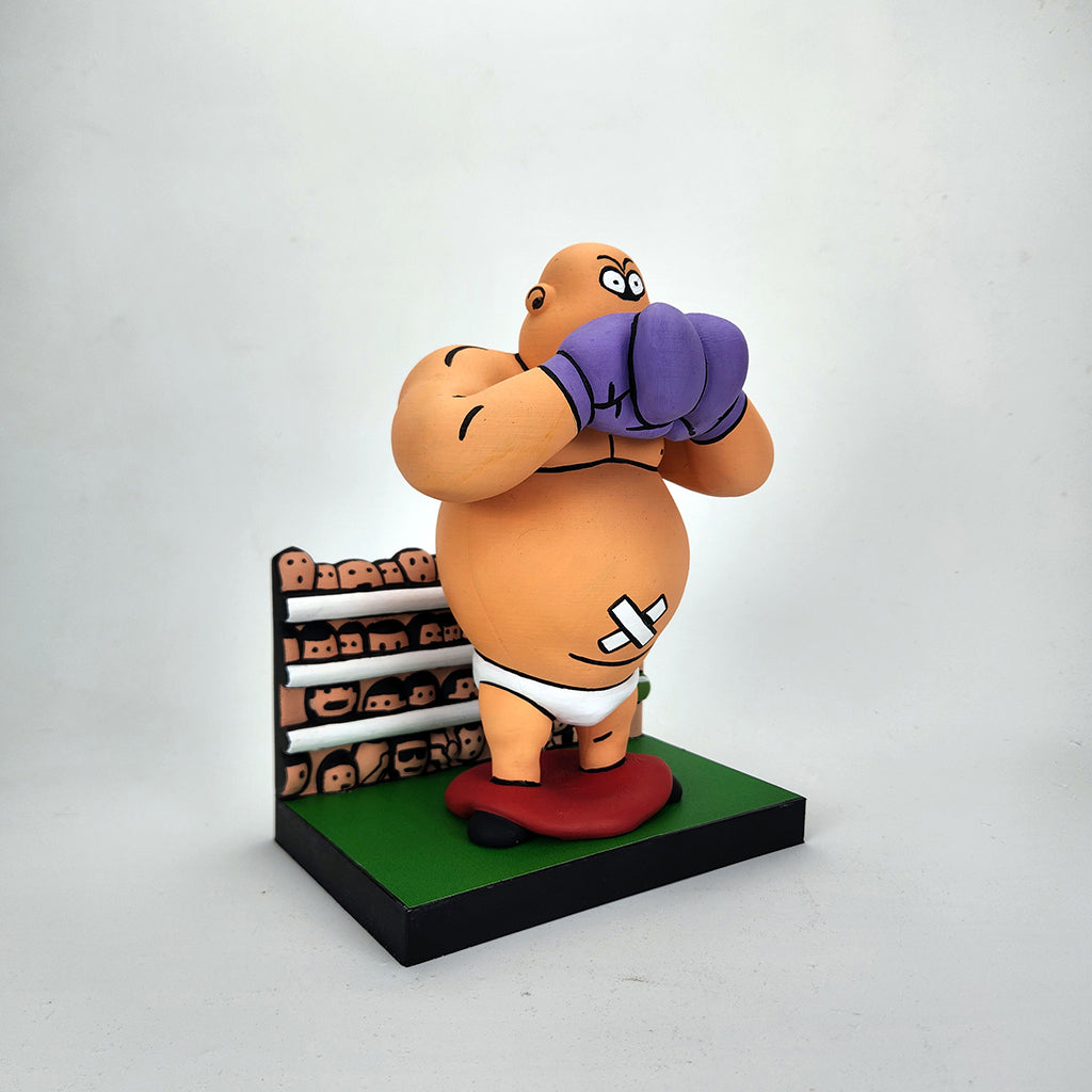 Geoff Trapp’s cartoon boxer figurine, with purple gloves, bandages, and white trunks, stands on a platform before a painted crowd—its worried face and rounded features evoke King Hippo from Mike Tyson’s Punchout.