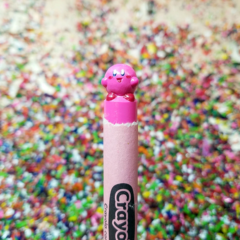 Pink crayon with a character on top against a colorful blurred background
