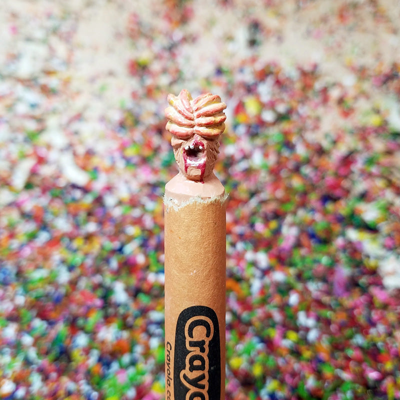 Crayon with a unique design on top against a colorful blurred background