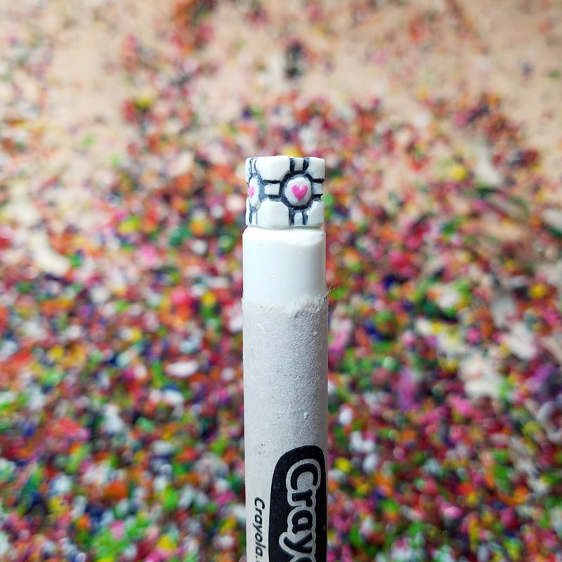 Crayola crayon with an artifact from Portal against a colorful background