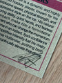 A close-up of a printed card from the Culyer Smith trading cards, with black text describing a hockey player, featuring a black autograph at the bottom on textured paper next to a wooden surface.