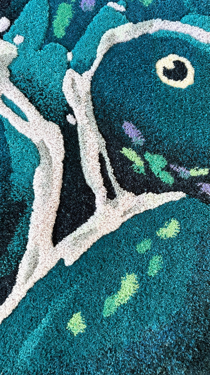 Close-up of a vibrant, abstract carpet in teal, blue, white, black, green, and purple—crafted from hand-dyed wool yarn and inspired by Jeany Ngo Wave for Spoke Art’s 15th Anniversary.