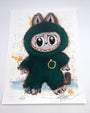 A whimsical archival print by Joey Feldman featuring a wide-eyed creature in a fuzzy green suit with pointy ears, claws, and a gold ring on its chest. Numbered 24/60 and signed at the bottom.