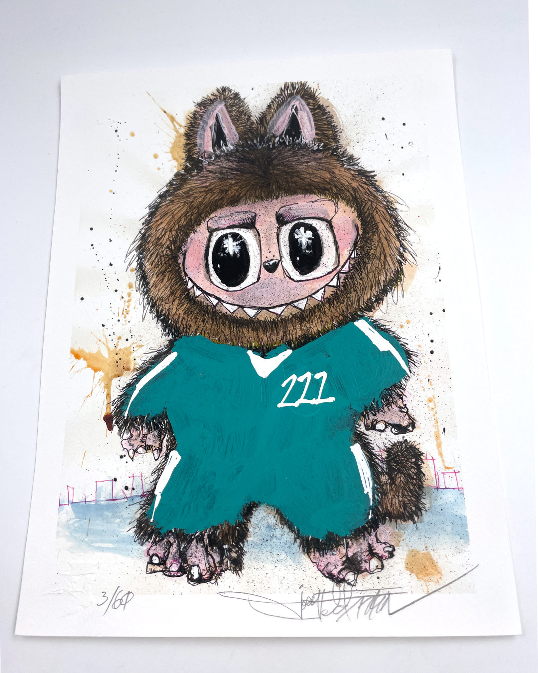 A whimsical Joey Feldman print shows a wide-eyed cartoon creature in a furry hood and teal 211 shirt, with splattered paint accents. Each archival pigment print is hand-embellished, signed, and numbered.