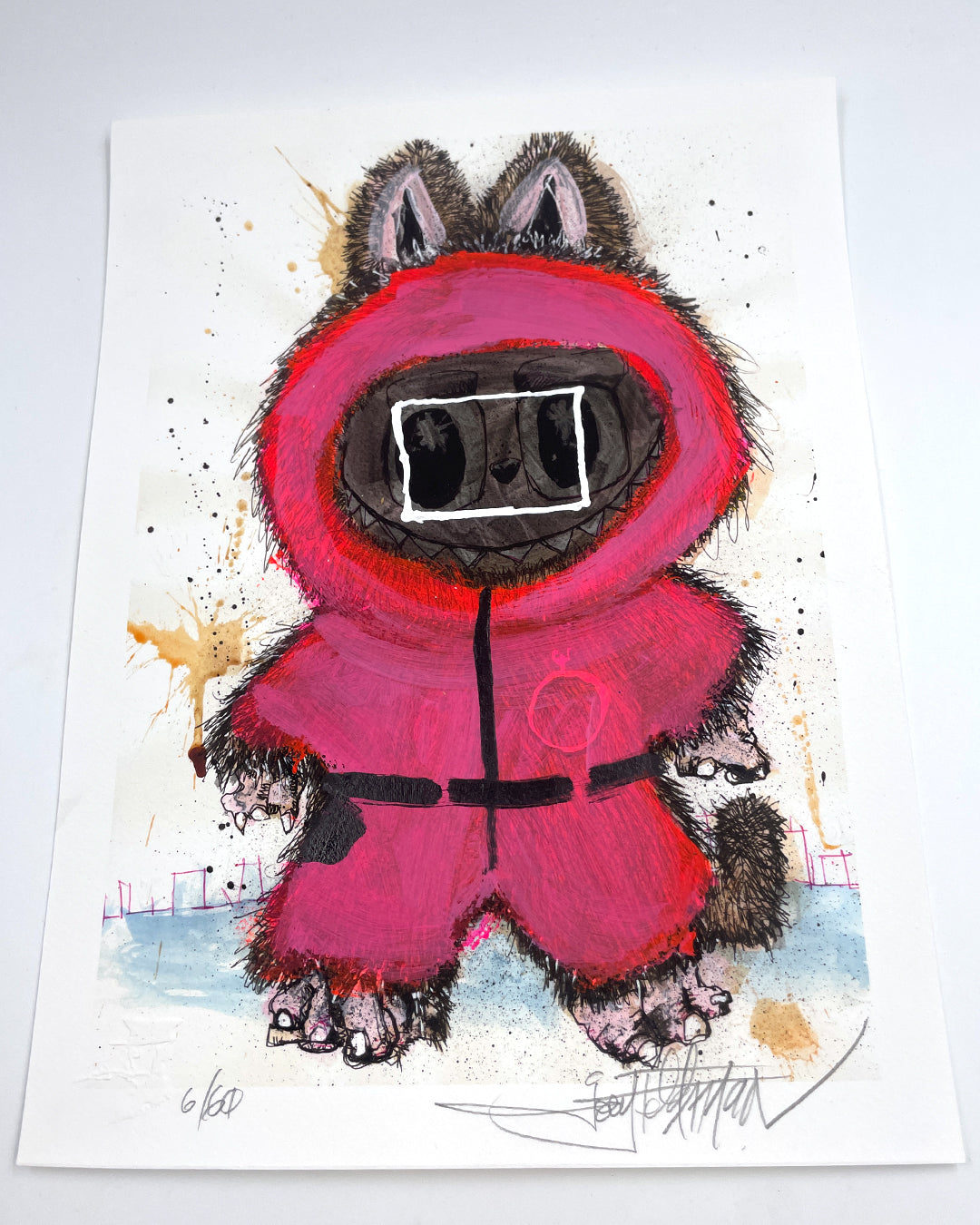 A whimsical Joey Feldman illustration shows a furry creature in a red hooded suit, black accents, and oversized sunglasses amid paint splatters. Hand-painted embellishments make each archival pigment print uniquely charming.