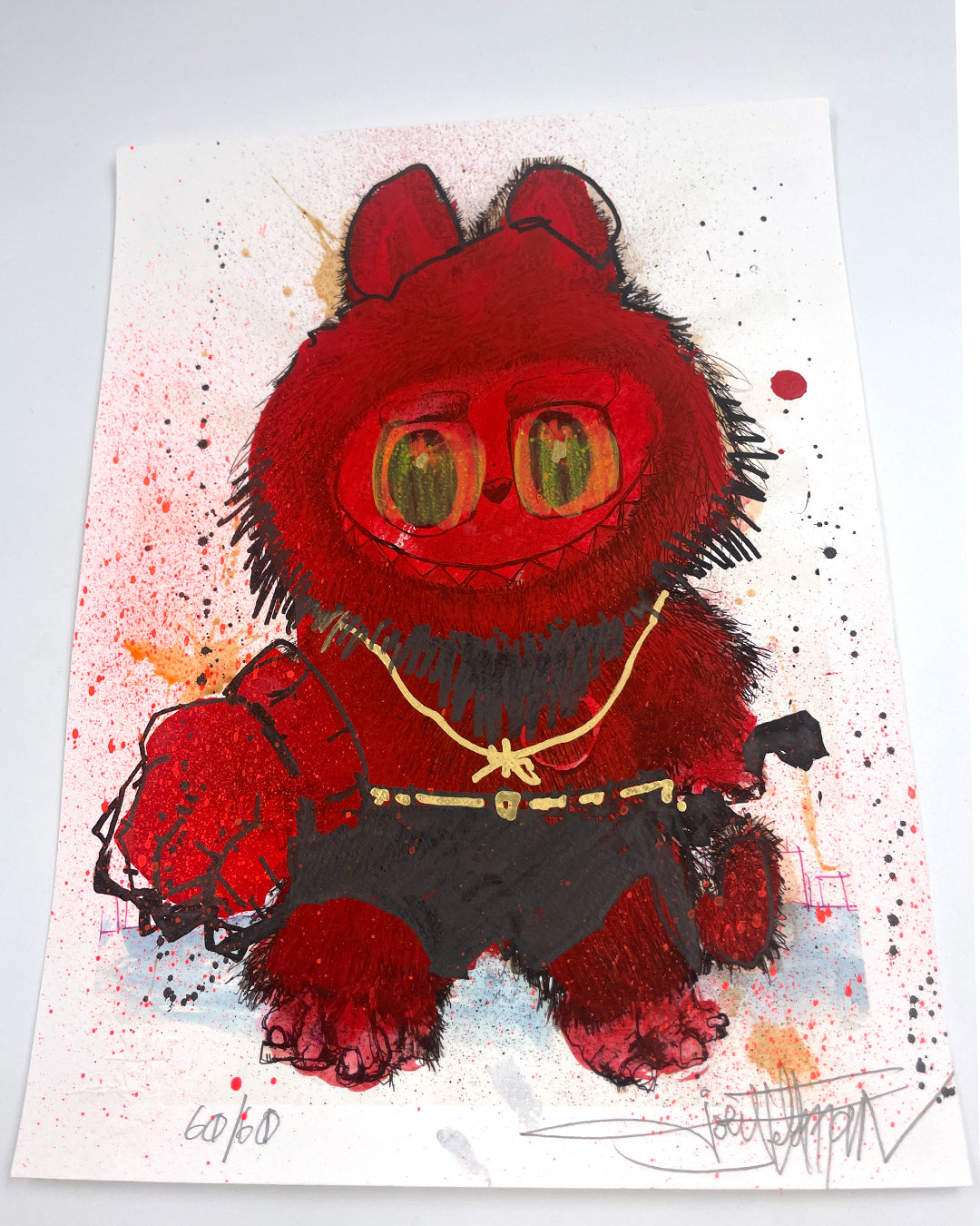 A Joey Feldman print shows a red, furry creature with big green eyes, gold chains, and black shorts holding a paintbrush, set against a background splattered with hand-painted red, orange, and black embellishments.