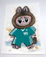 A whimsical creature with big eyes, wide grin, and furry brown ears in a teal 444 jersey stands on paint-splattered paper in this signed, numbered Joey Feldman archival pigment print.